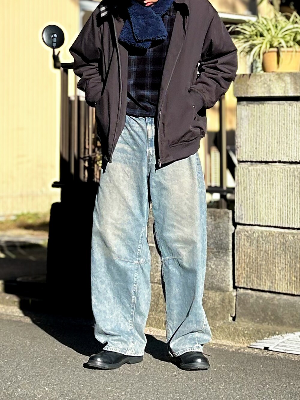 ブラック系のニット/セーター、ブルー系のデニムパンツ、ブラック系のシューズを着用したメンズの秋コーディネートの2枚目の写真