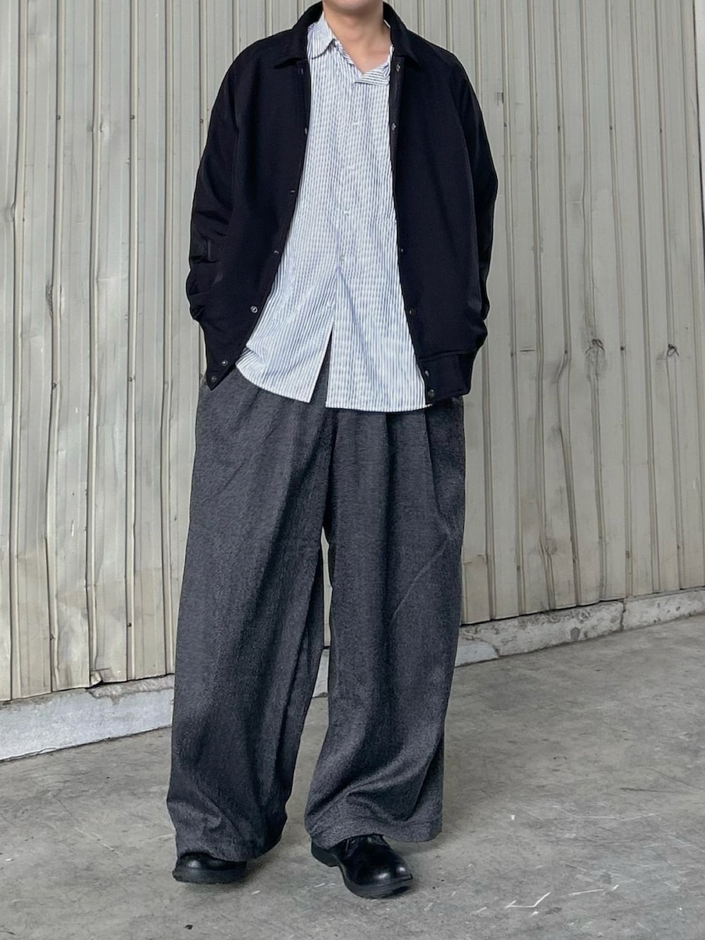 グレー系のシャツ/ブラウス、ブラック系のスラックス、ブラック系のシューズを着用したメンズの秋コーディネートの2枚目の写真