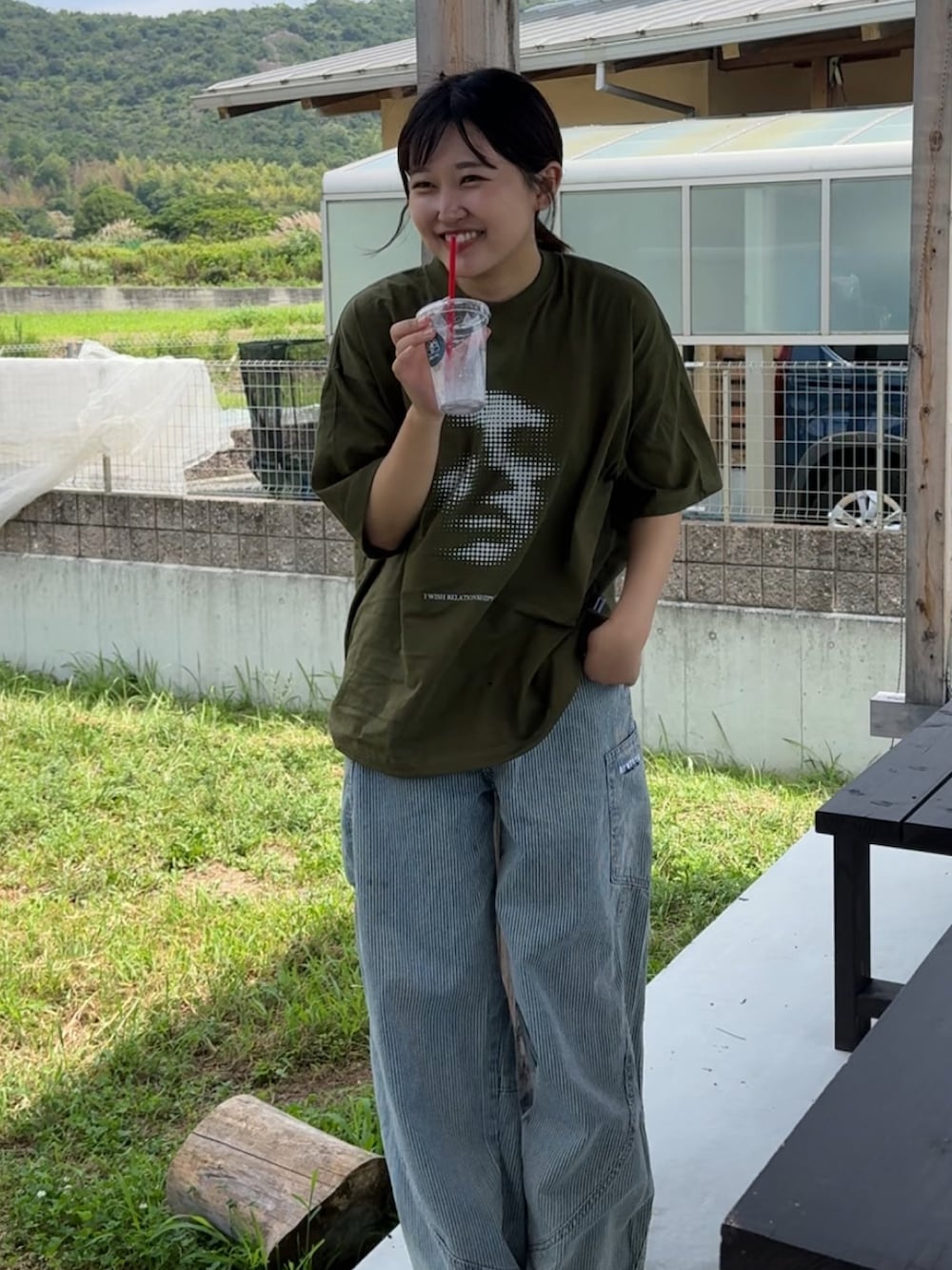 グリーン系のTシャツ/カットソー、ブラック系のサンダルを着用したレディースの夏コーディネートの3枚目の写真