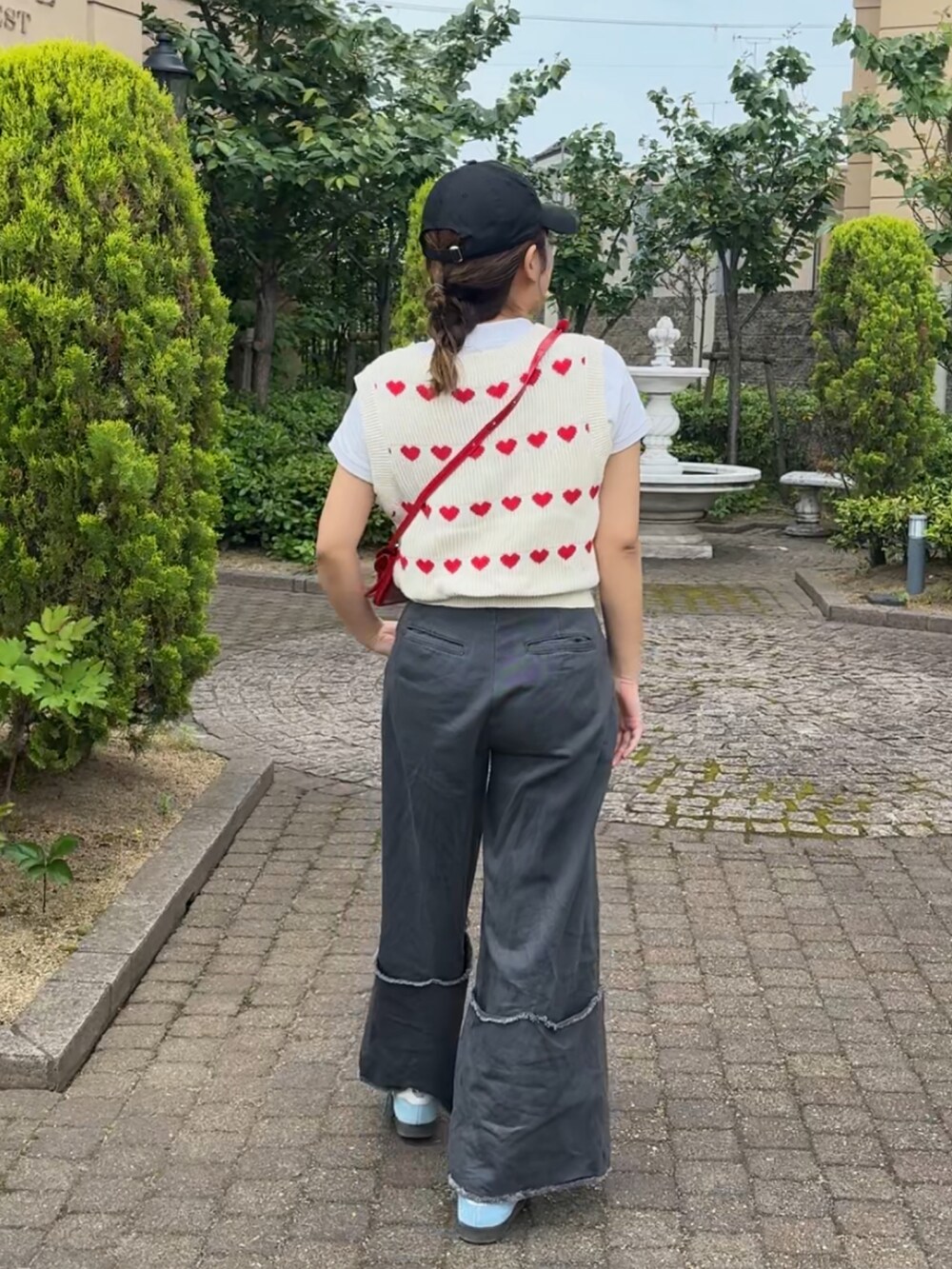 ホワイト系のニット/セーター、グレー系のデニムパンツ、レッド系のショルダーバッグを着用したレディースの春コーディネートの5枚目の写真