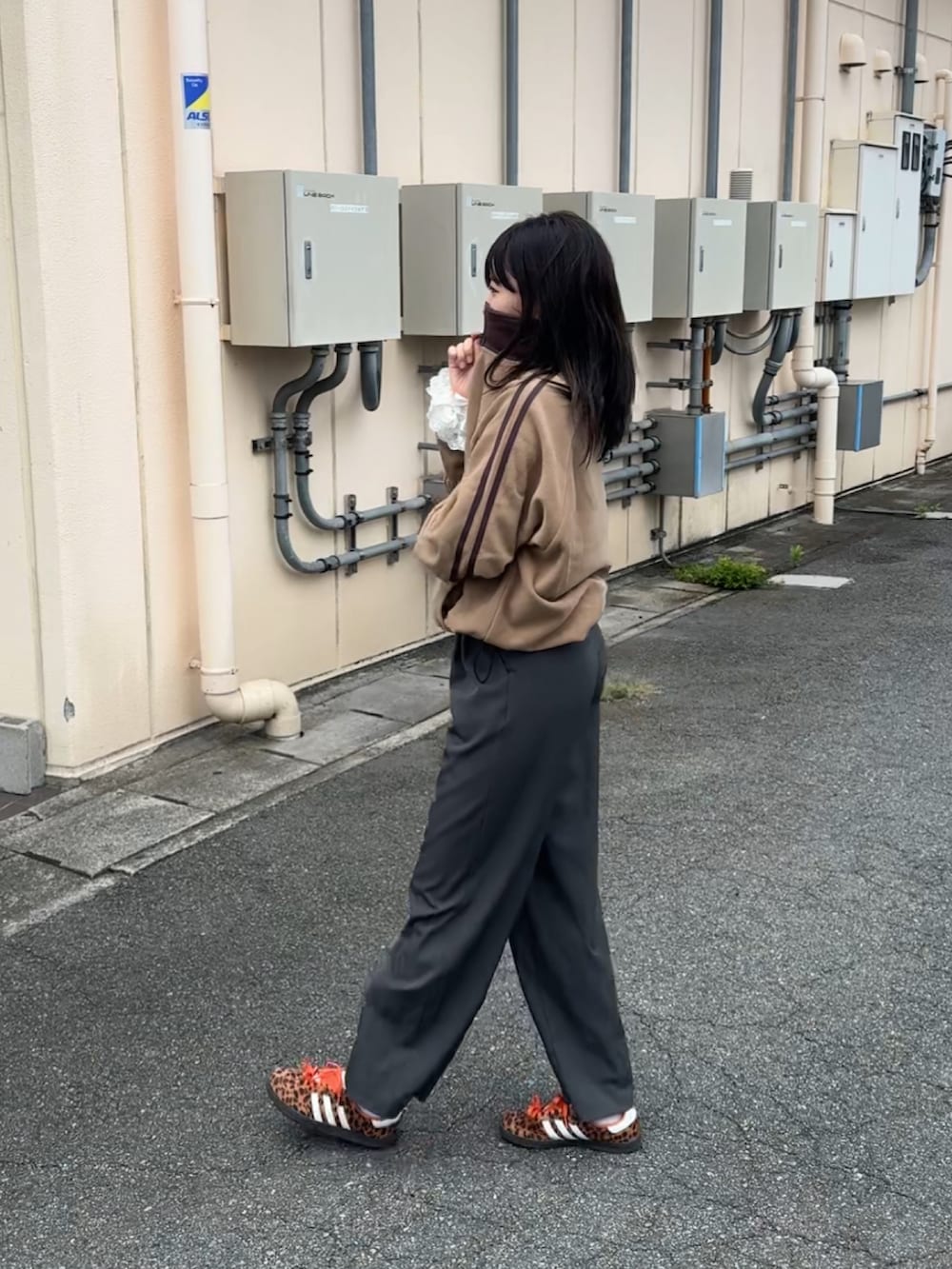 グレー系のスラックス、ベージュ系のスウェットを着用したレディースの秋コーディネートの2枚目の写真