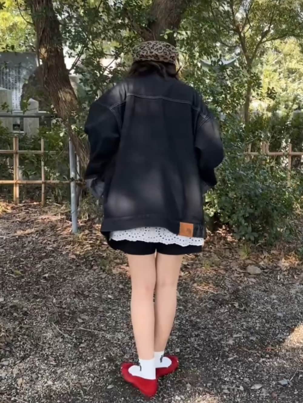 レッド系のショルダーバッグ、ブルー系のパンプス、ブラック系のデニムジャケットを着用したレディースの春コーディネートの2枚目の写真