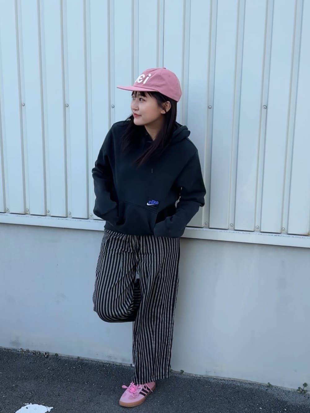 イエロー系のスニーカー、ピンク系の帽子を着用したレディースの冬コーディネートの2枚目の写真