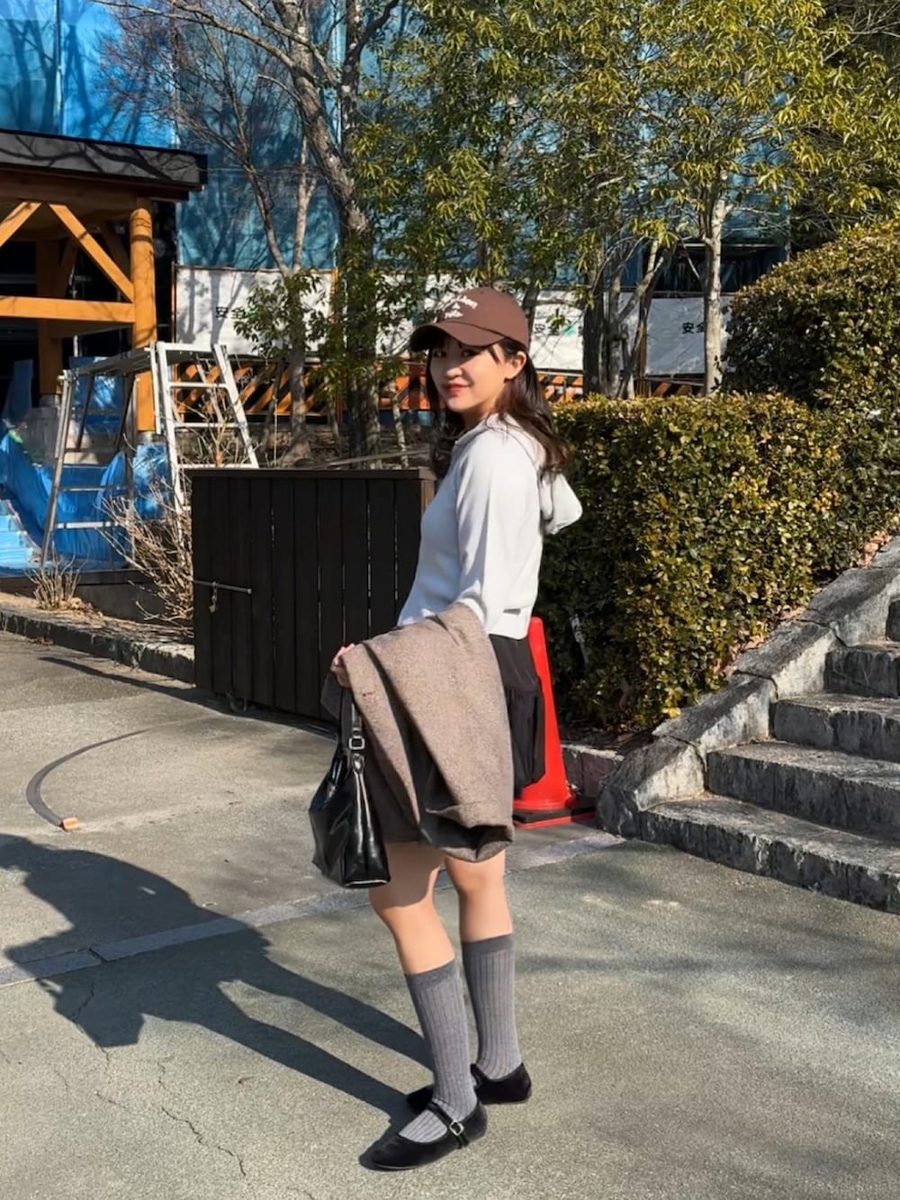 ブラック系のバレエシューズ、ブラック系のトートバッグ、ブルー系のパーカーを着用したレディースの冬コーディネートの4枚目の写真