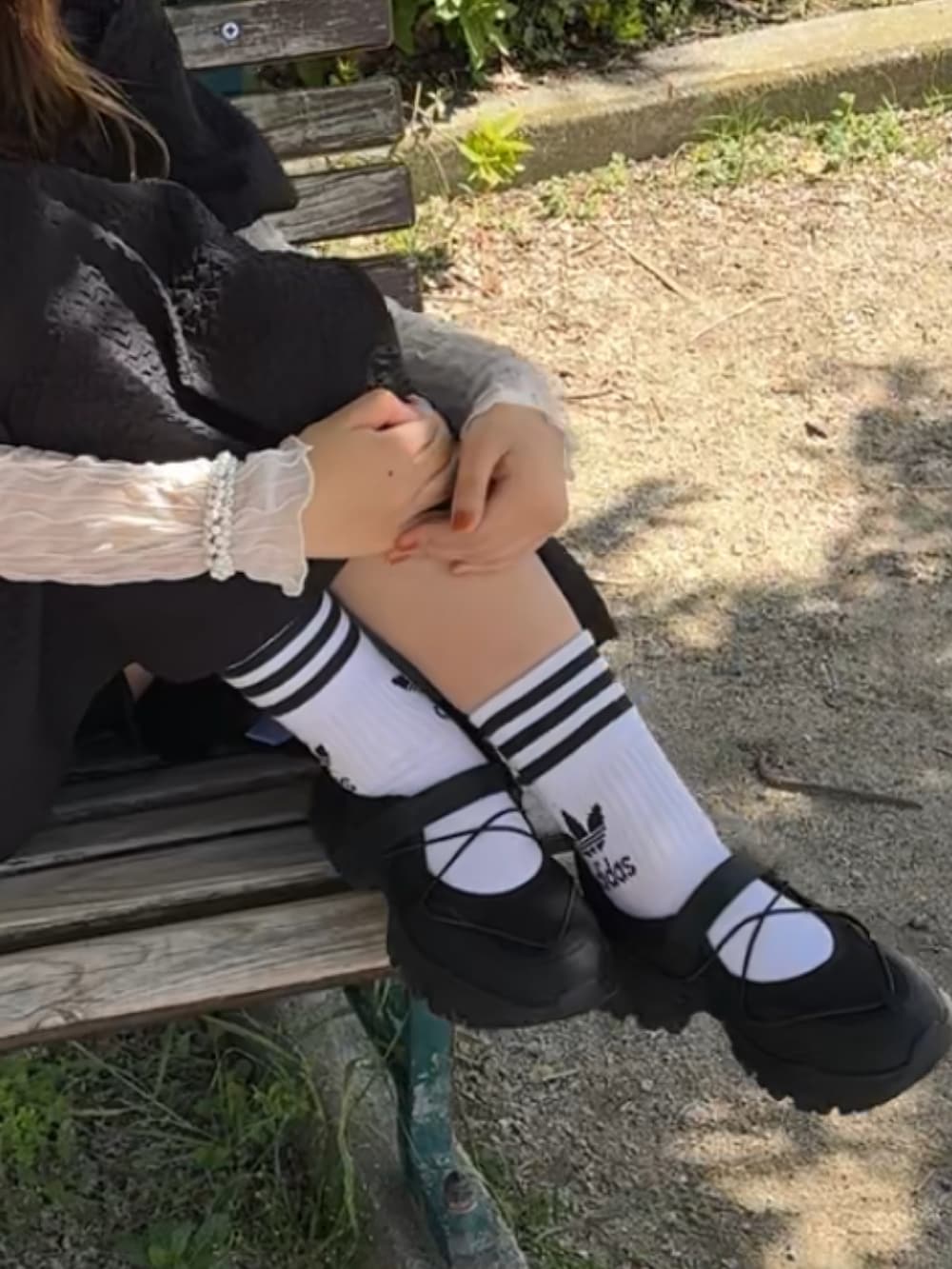 シルバー系のショルダーバッグ、ブラック系のワンピース、ホワイト系のソックス/靴下を着用したレディースの春コーディネートの2枚目の写真