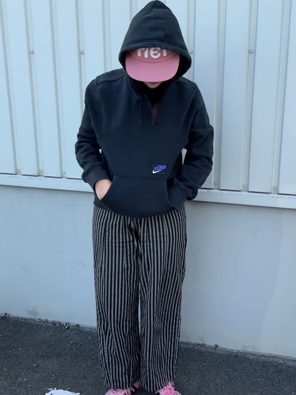 イエロー系のスニーカー、ピンク系の帽子を着用したレディースの冬コーディネートの3枚目の写真