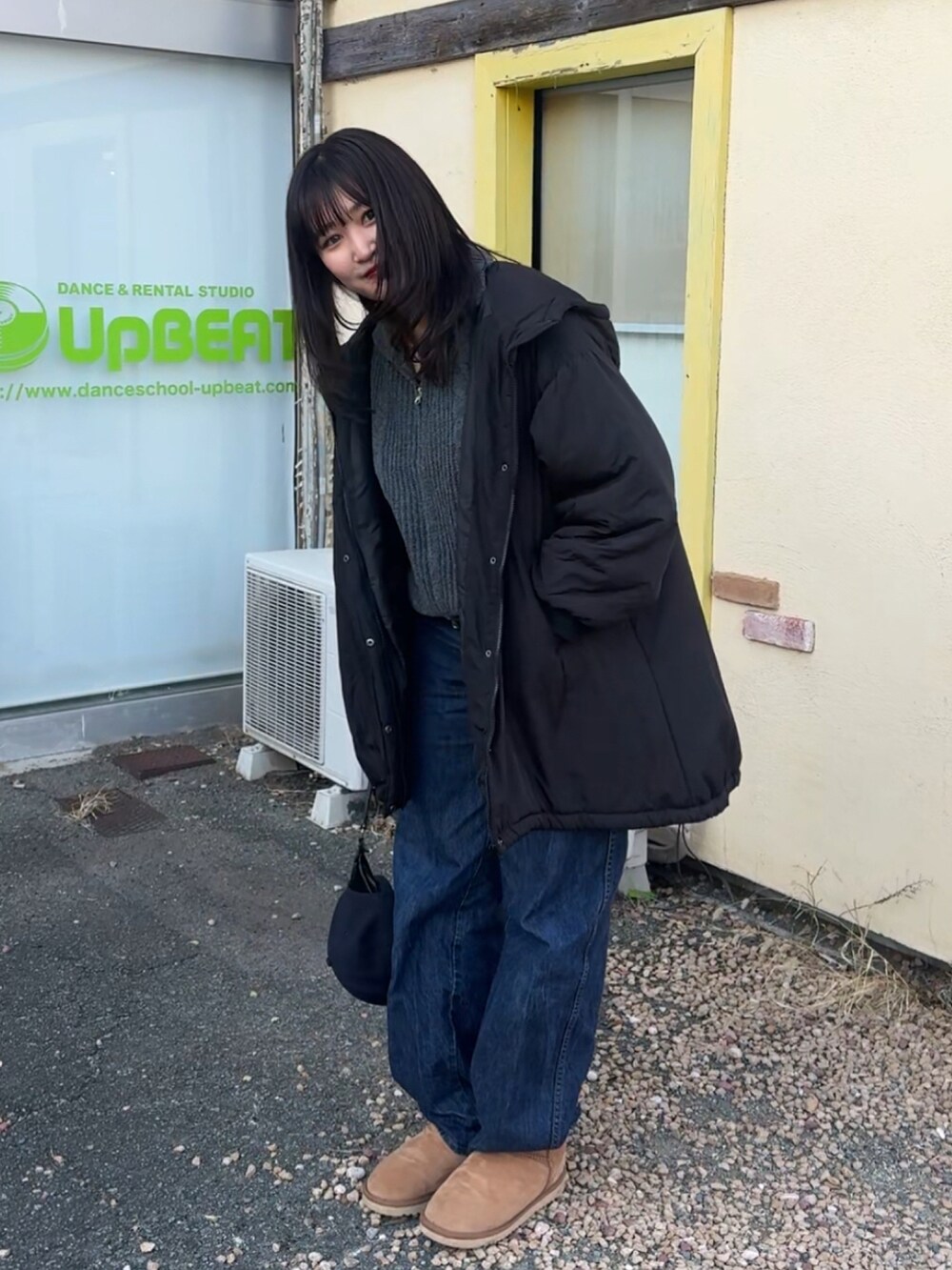 ブラウン系のブーツ、ブラック系のトートバッグ、ブルー系のキャップを着用したレディースの冬コーディネートの4枚目の写真