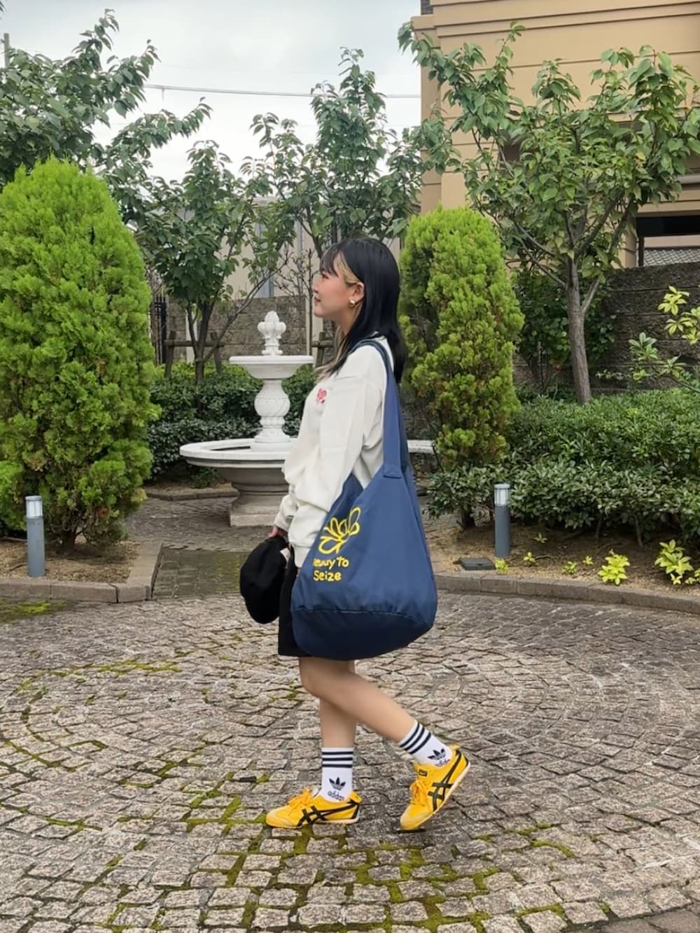 その他のTシャツ/カットソー、ブルー系のトートバッグ、イエロー系のスニーカーを着用したレディースの秋コーディネートの2枚目の写真