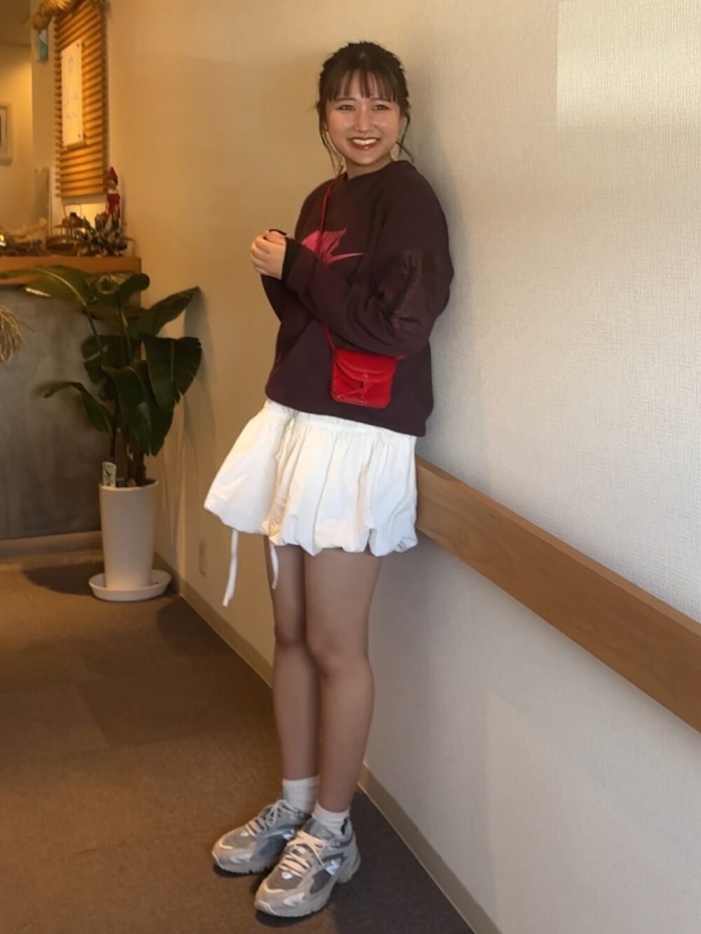 パープル系のスウェット、レッド系のショルダーバッグ、ホワイト系のその他パンツを着用したレディースの春コーディネートの2枚目の写真