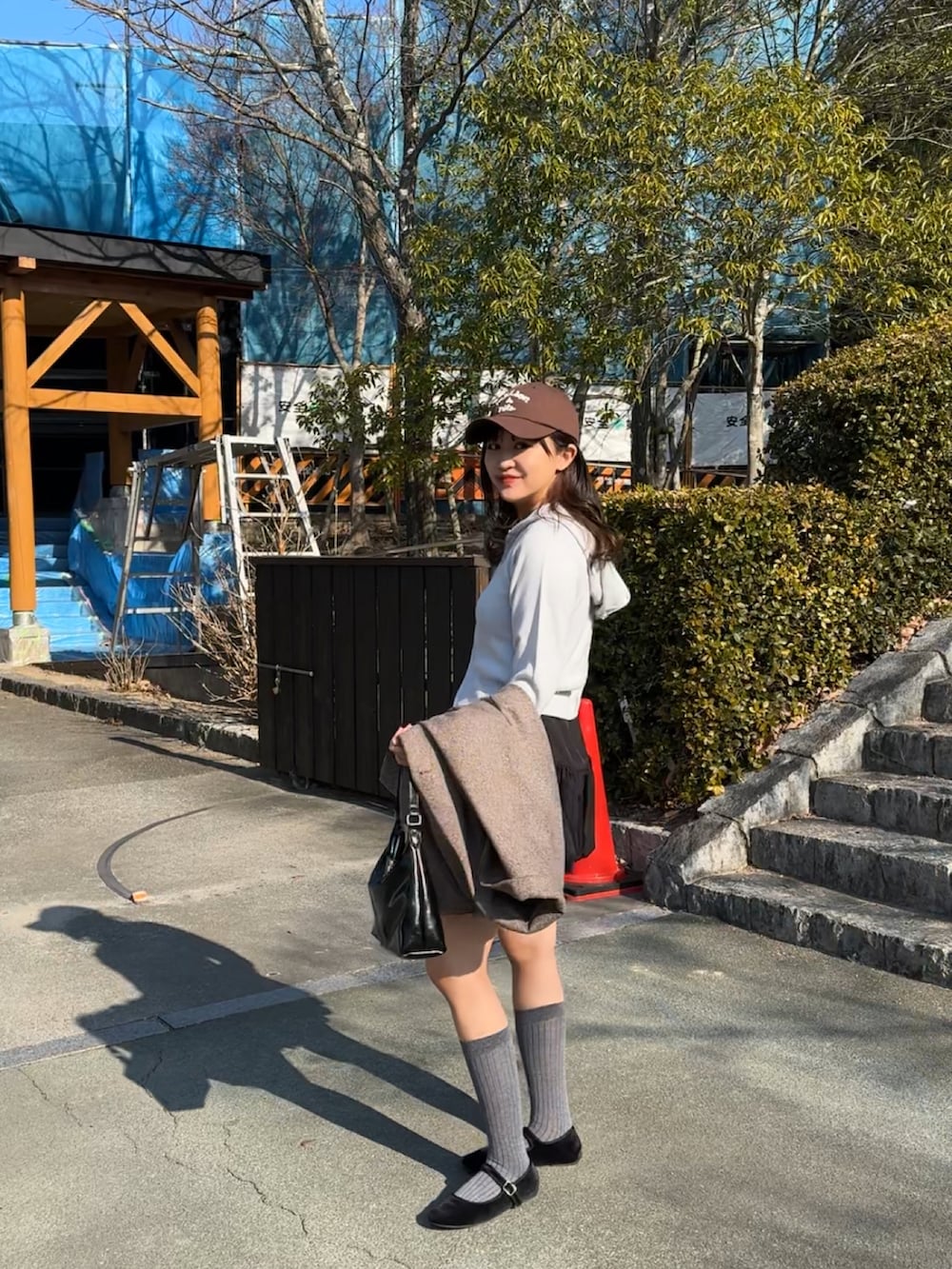 ブラック系のバレエシューズ、ブラック系のトートバッグ、ブルー系のパーカーを着用したレディースの冬コーディネートの3枚目の写真