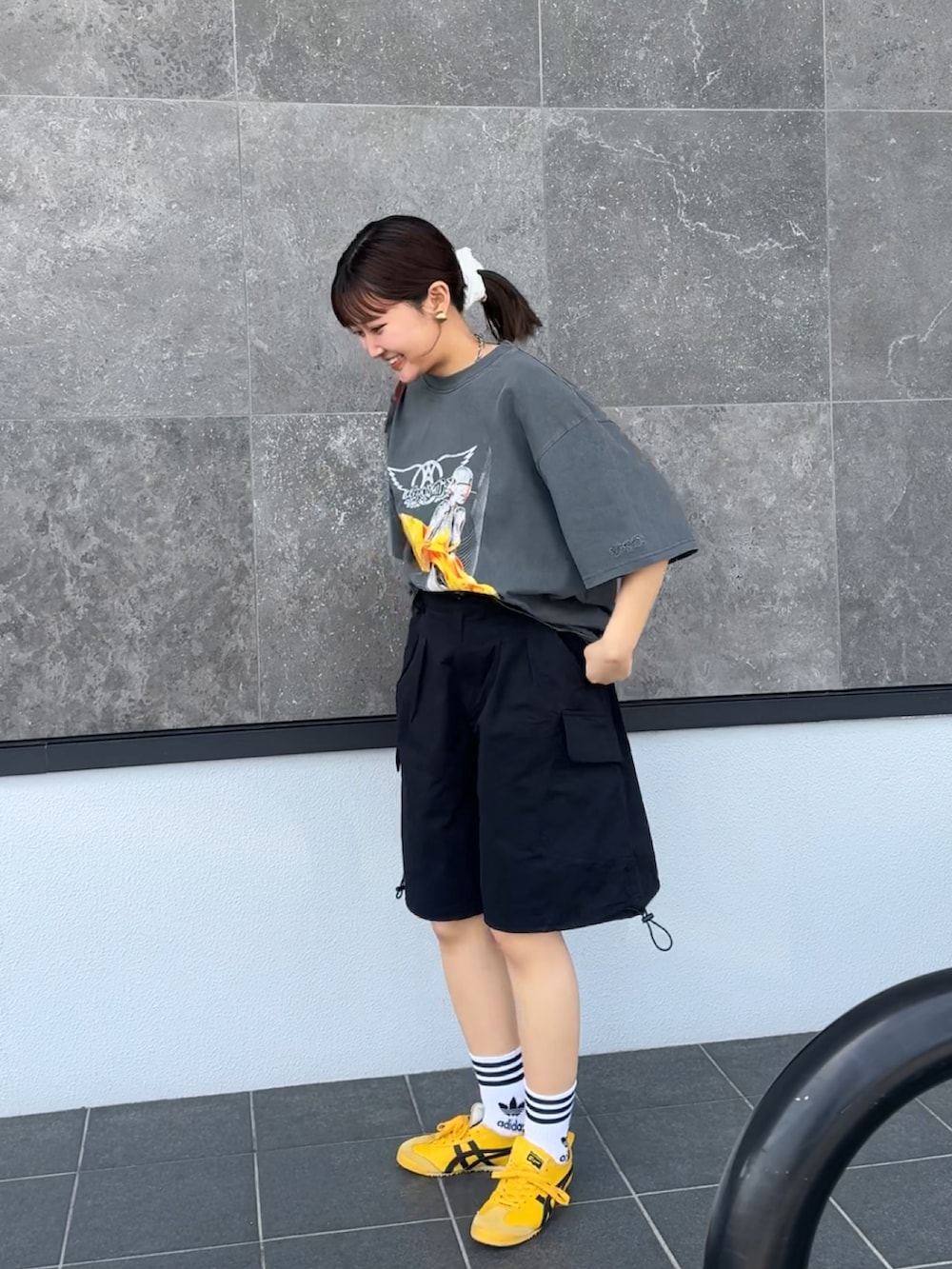 ブラック系のTシャツ/カットソー、ブラック系のカーゴパンツ、イエロー系のスニーカーを着用したレディースの春コーディネートの3枚目の写真