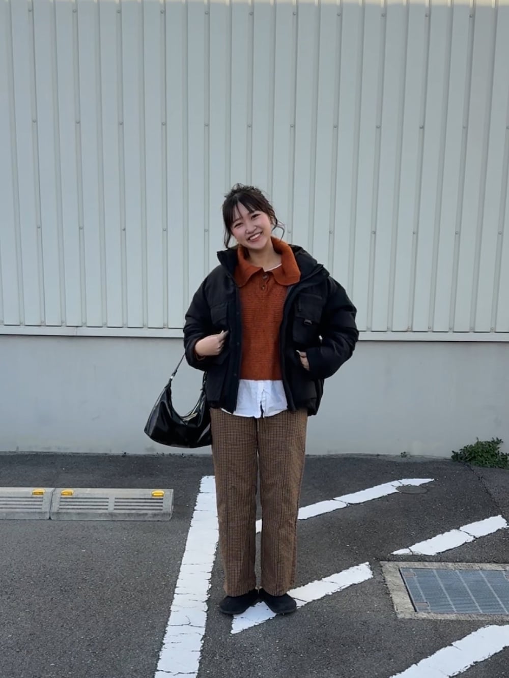 オレンジ系のニット/セーター、ブラック系のトートバッグ、ブラック系のサンダルを着用したレディースの冬コーディネートの3枚目の写真