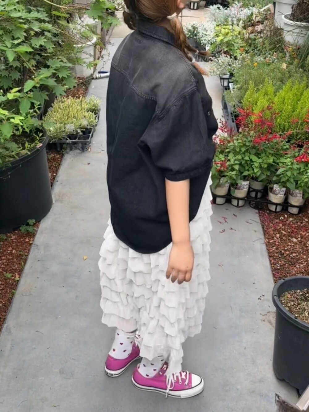 ピンク系のスニーカー、ブラック系のシャツ/ブラウスを着用したレディースの春コーディネートの2枚目の写真