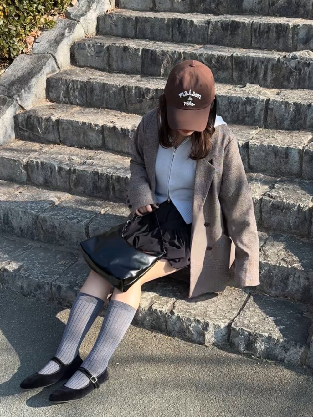 ブラック系のバレエシューズ、ブラック系のトートバッグ、ブルー系のパーカーを着用したレディースの冬コーディネートの2枚目の写真