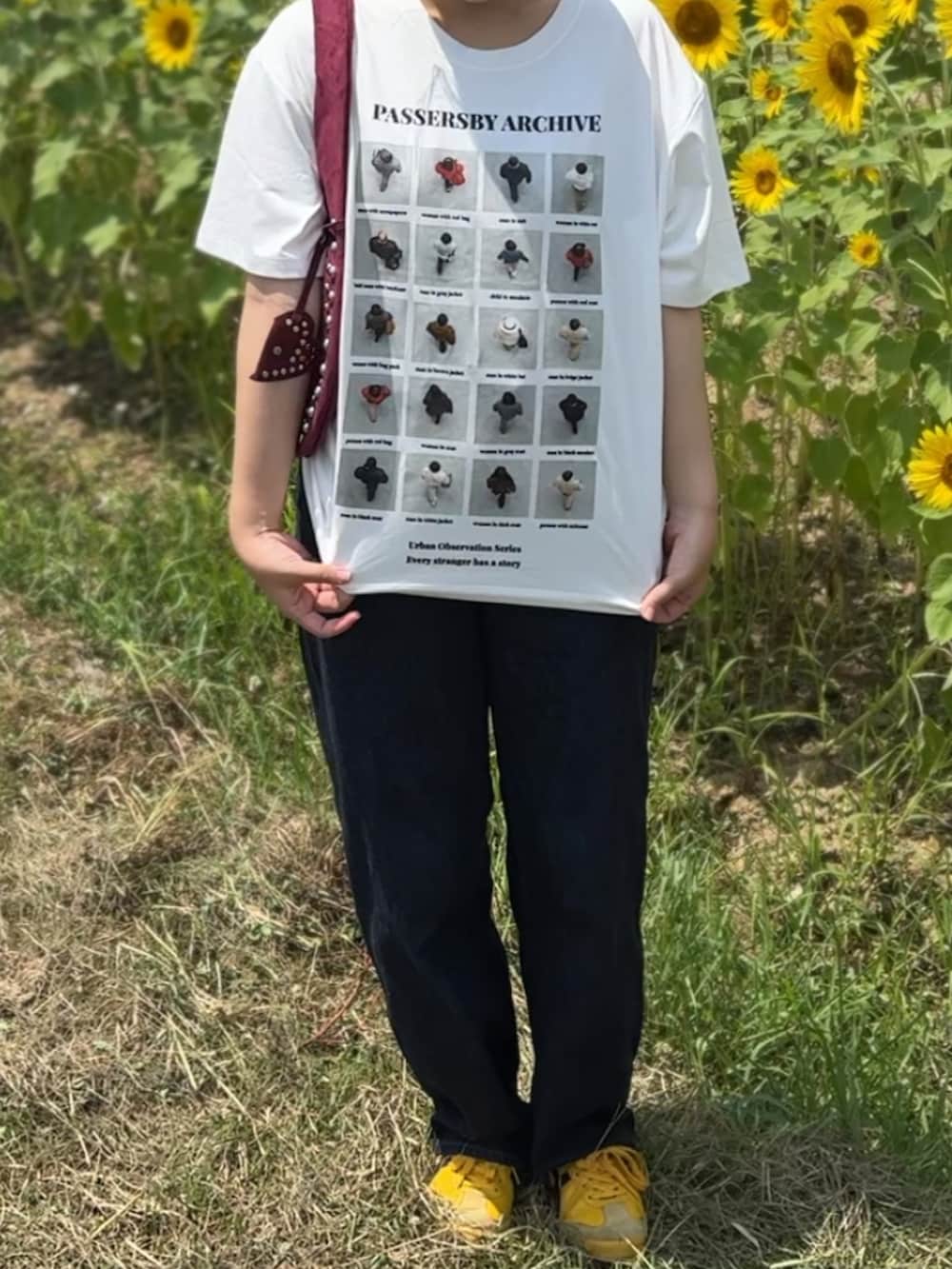 レッド系のハンドバッグ、ホワイト系のTシャツ/カットソー、イエロー系のスニーカーを着用したレディースの夏コーディネートの2枚目の写真