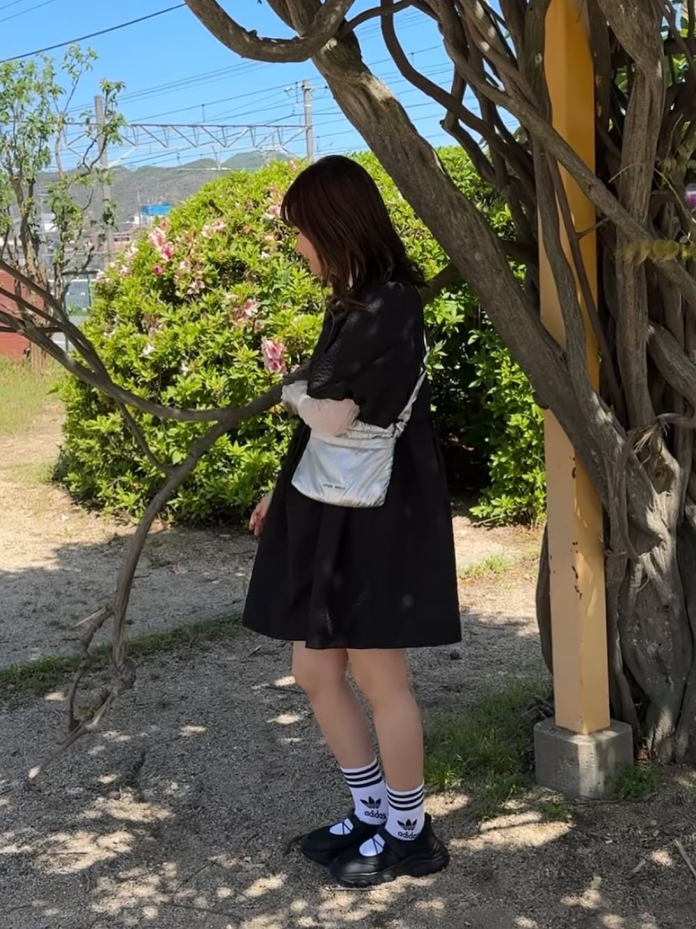 シルバー系のショルダーバッグ、ブラック系のワンピース、ホワイト系のソックス/靴下を着用したレディースの春コーディネートの3枚目の写真