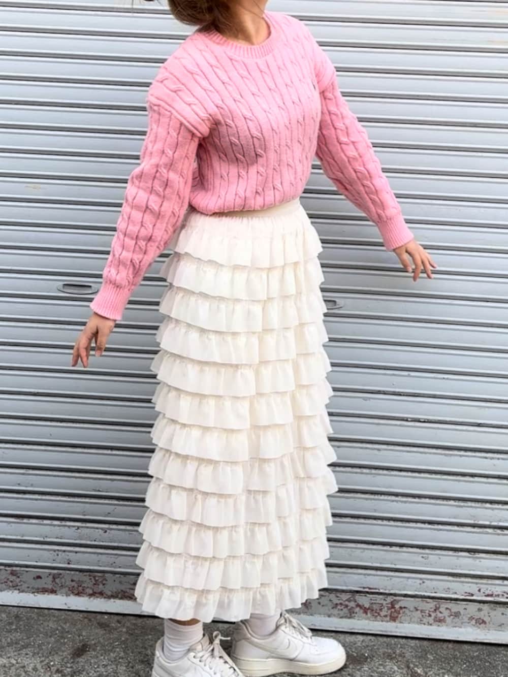 ピンク系のニット/セーター、ホワイト系のスニーカーを着用したレディースの春コーディネートの3枚目の写真