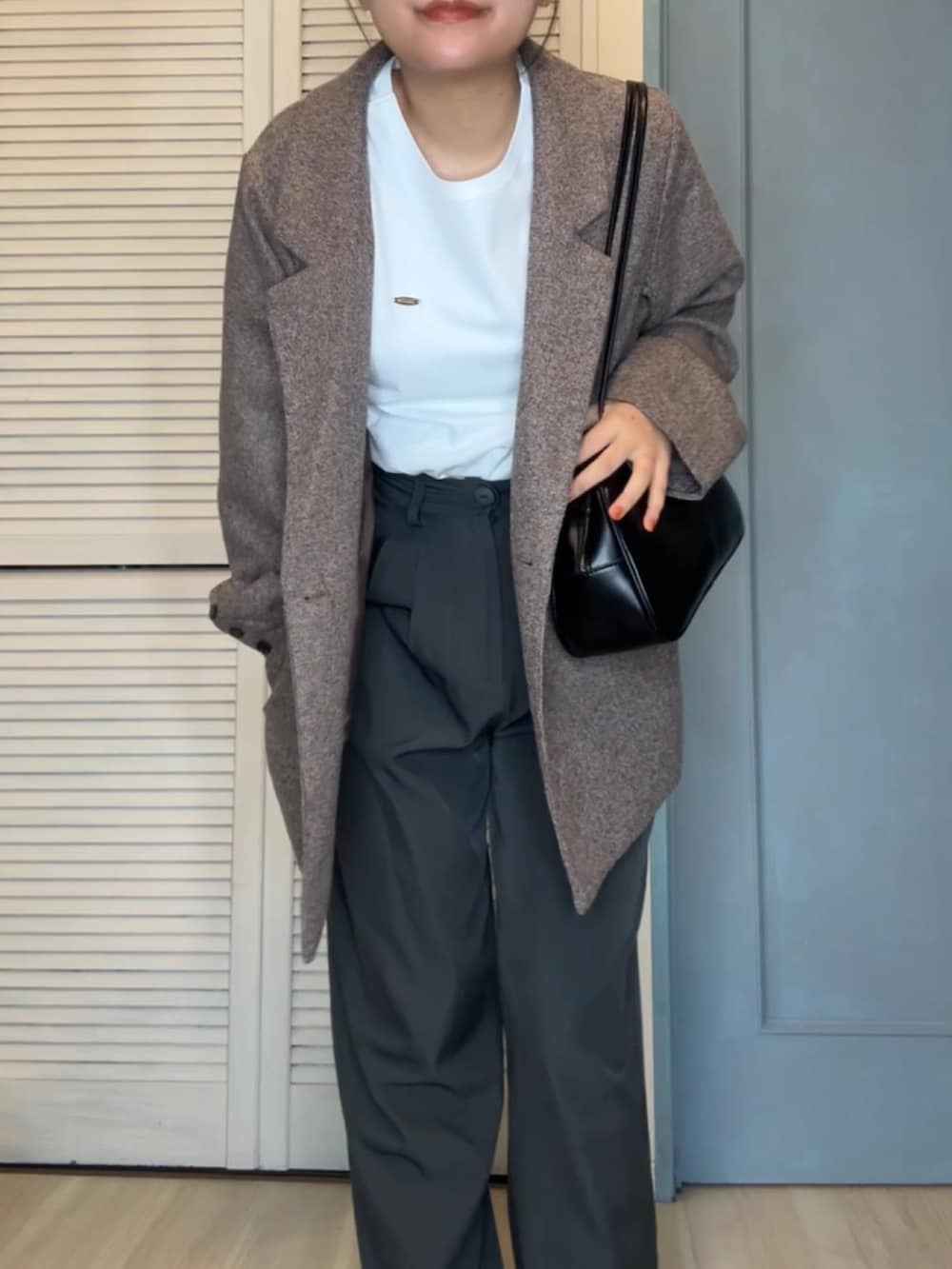 ブラウン系のテーラードジャケット、ホワイト系のトップス、グレー系のスラックスを着用したレディースの春コーディネートの2枚目の写真