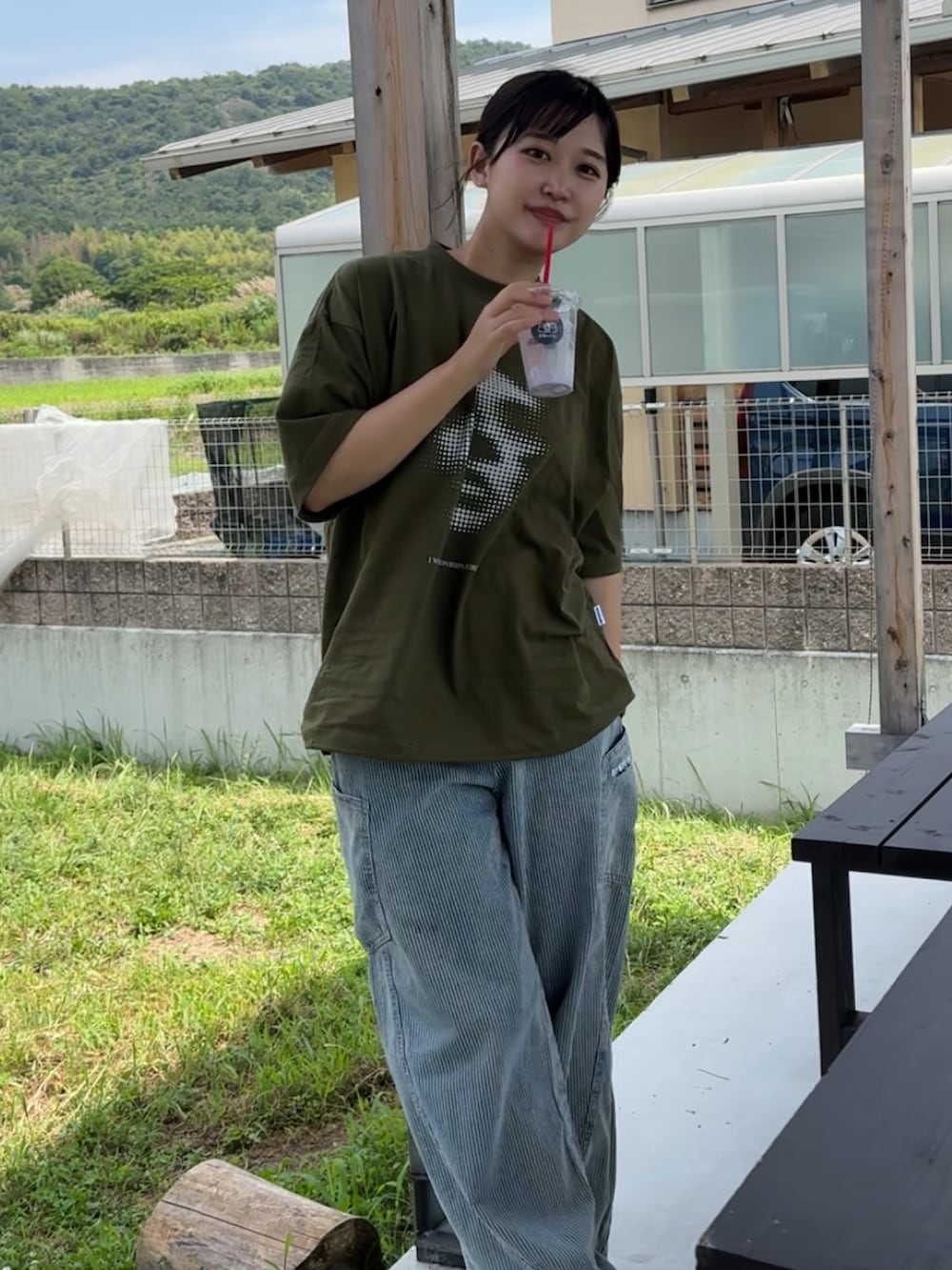 グリーン系のTシャツ/カットソー、ブラック系のサンダルを着用したレディースの夏コーディネートの2枚目の写真