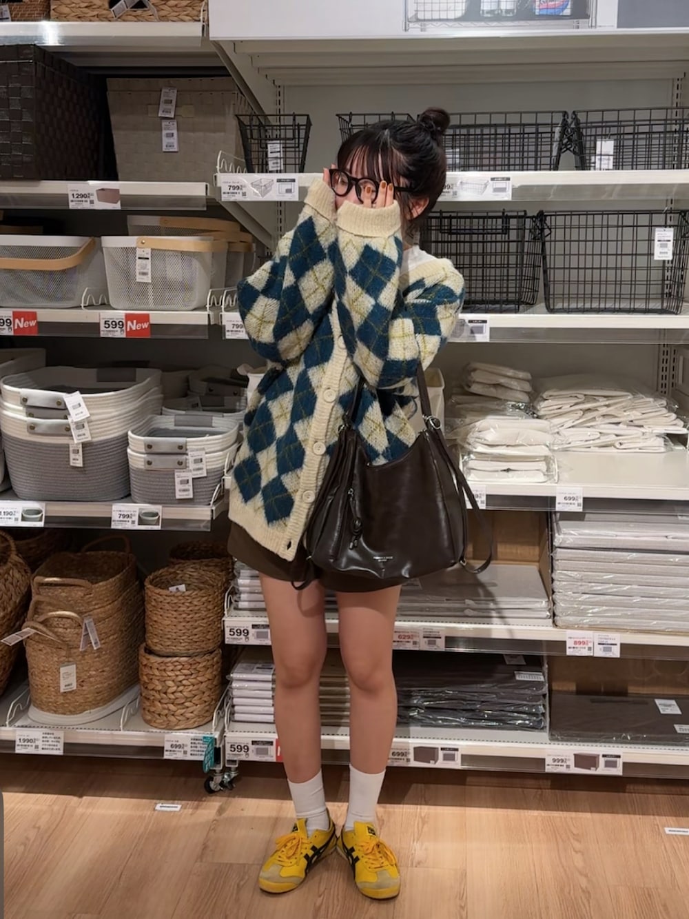 ホワイト系のカーディガン/ボレロ、イエロー系のスニーカーを着用したレディースの冬コーディネートの4枚目の写真