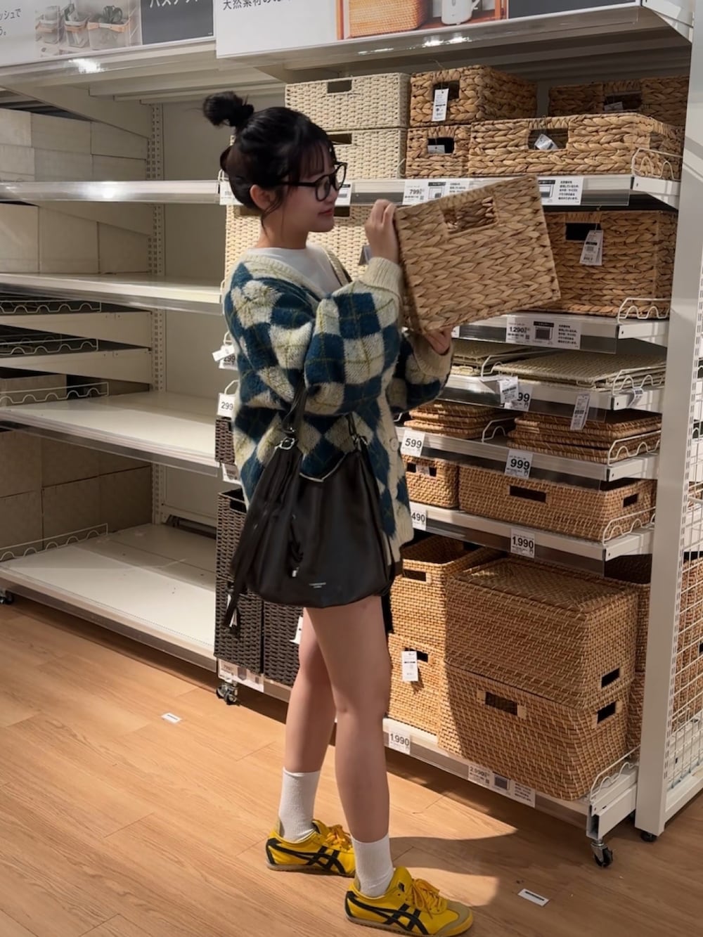 ホワイト系のカーディガン/ボレロ、イエロー系のスニーカーを着用したレディースの冬コーディネートの2枚目の写真