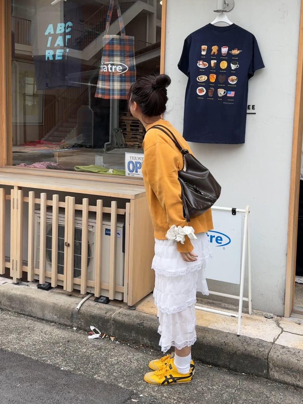 ホワイト系のワンピース、イエロー系のスニーカー、ホワイト系のシュシュを着用したレディースの春コーディネートの2枚目の写真