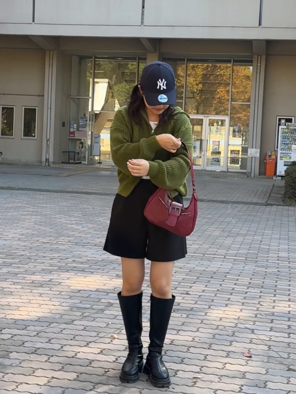 ブラック系のブーツ、ブラック系のその他パンツ、ブルー系のキャップを着用したレディースの秋コーディネートの2枚目の写真