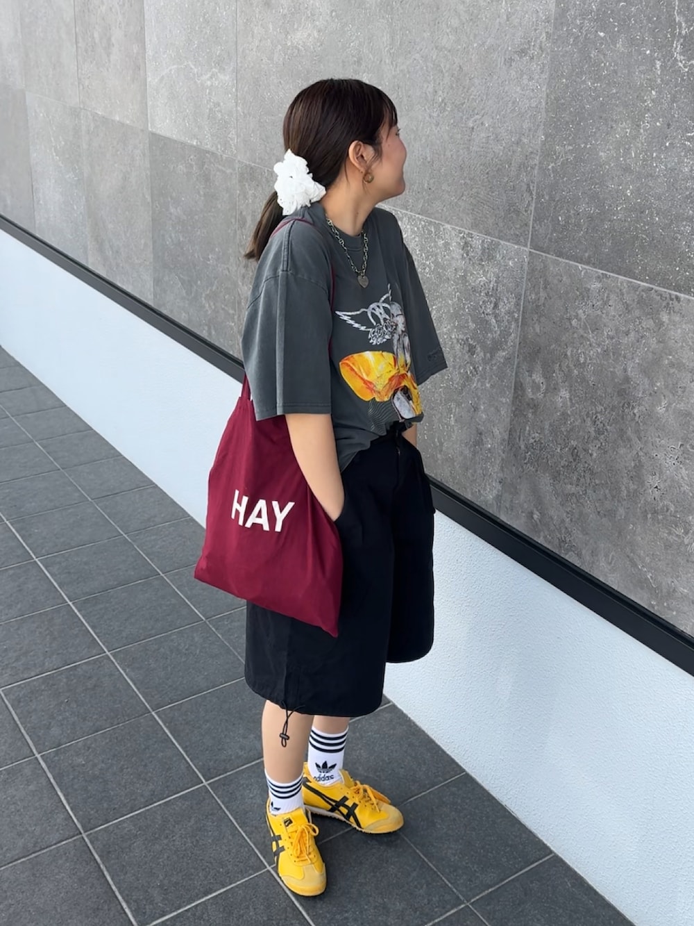 ブラック系のTシャツ/カットソー、ブラック系のカーゴパンツ、イエロー系のスニーカーを着用したレディースの春コーディネートの2枚目の写真