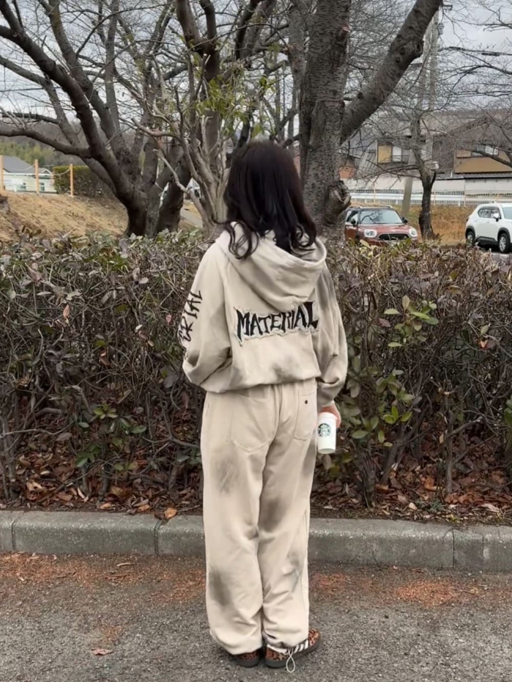 ホワイト系のジャージ、ブラック系のスニーカーを着用したレディースの冬コーディネートの3枚目の写真