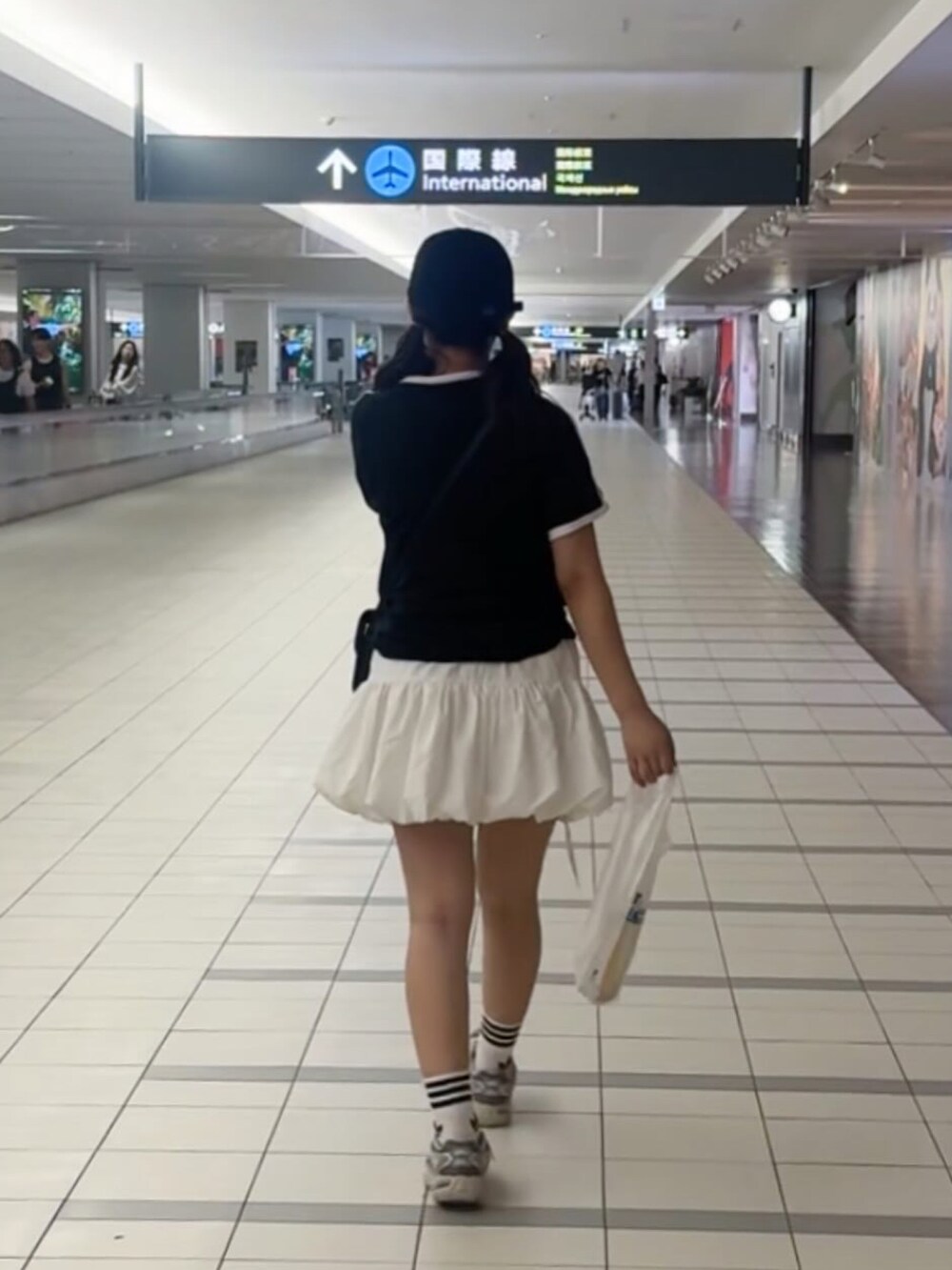 ブラック系のTシャツ/カットソー、ホワイト系のその他パンツ、シルバー系のスニーカーを着用したレディースの夏コーディネートの4枚目の写真