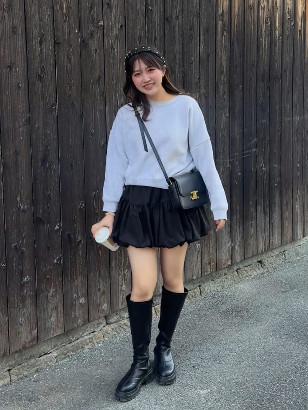 ホワイト系のスウェット、ブラック系のブーツ、ブラック系のショルダーバッグを着用したレディースの冬コーディネートの3枚目の写真