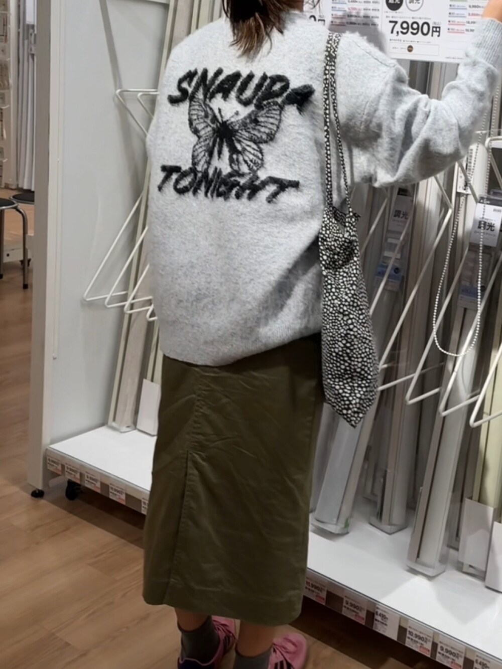 グレー系のニット/セーター、ブラック系のトートバッグ、イエロー系のスニーカーを着用したレディースの秋コーディネートの2枚目の写真