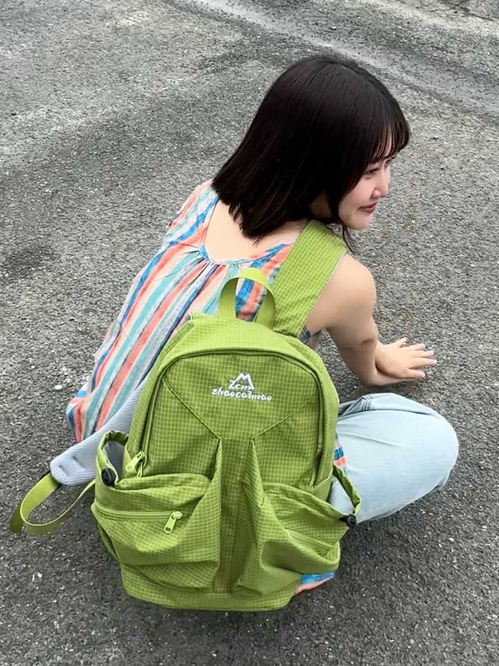 ブラック系のサンダル、ブルー系のデニムパンツを着用したレディースの春コーディネートの2枚目の写真