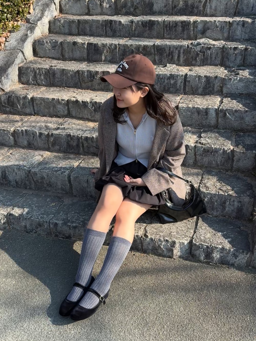 ブラック系のバレエシューズ、ブラック系のトートバッグ、ブルー系のパーカーを着用したレディースの冬コーディネートの5枚目の写真