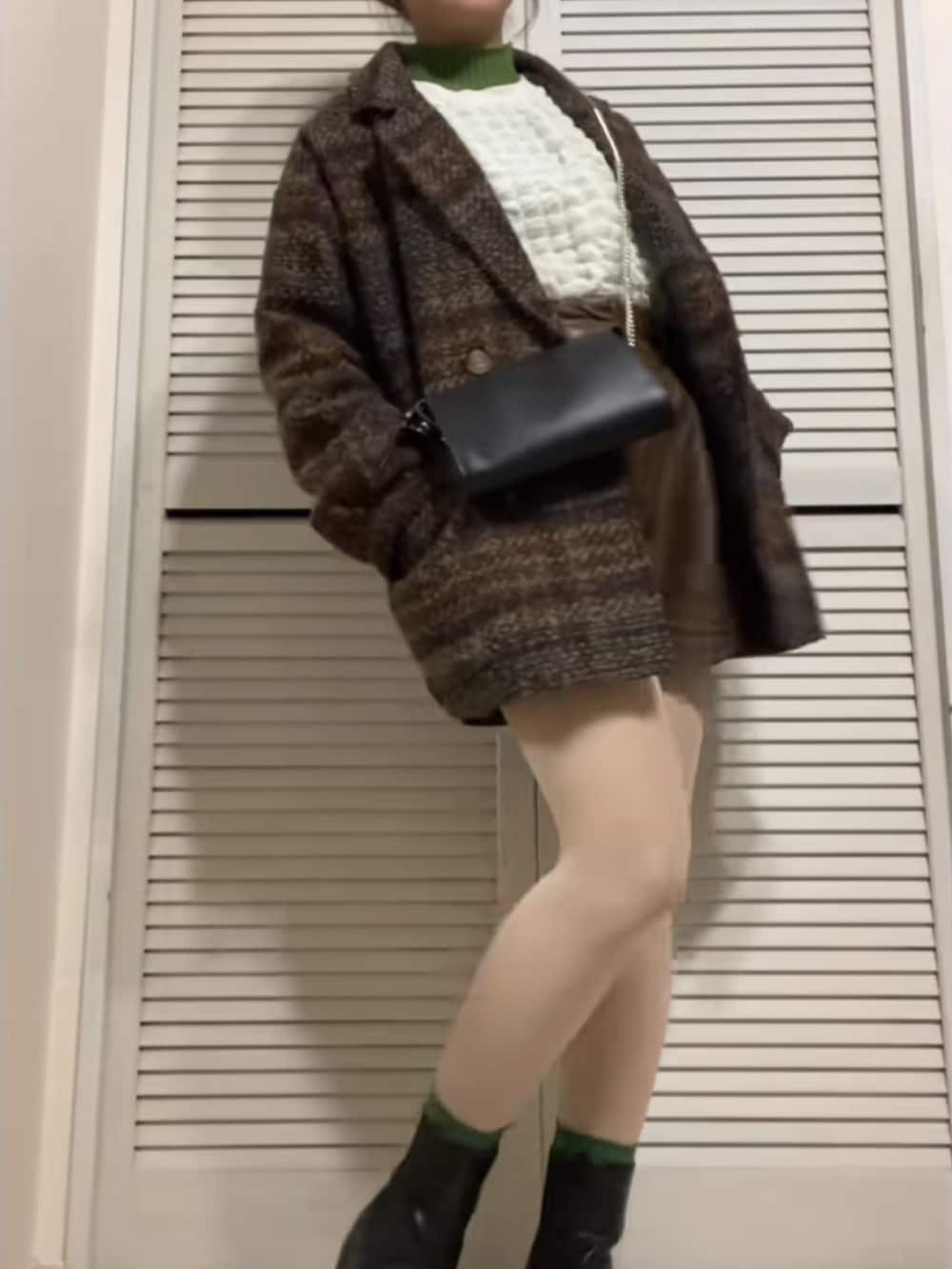 ブラウン系のテーラードジャケット、ホワイト系のTシャツ/カットソー、ブラック系のショルダーバッグを着用したレディースの冬コーディネートの2枚目の写真