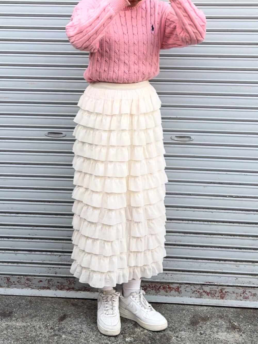 ピンク系のニット/セーター、ホワイト系のスニーカーを着用したレディースの春コーディネートの2枚目の写真