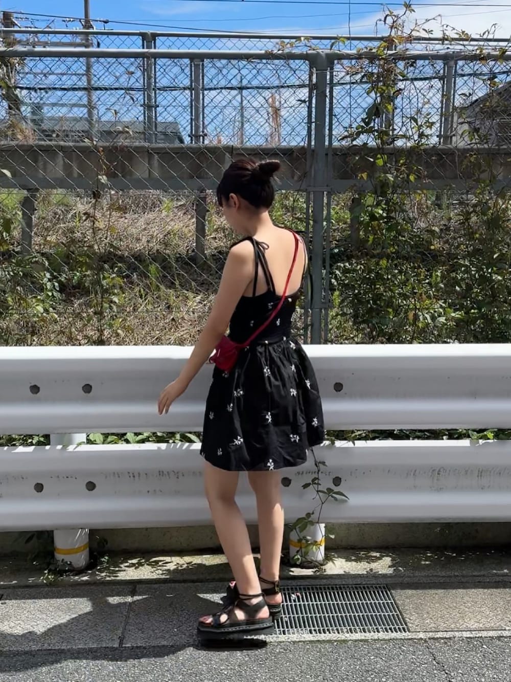 レッド系のショルダーバッグ、ブラック系のサンダルを着用したレディースの夏コーディネートの3枚目の写真