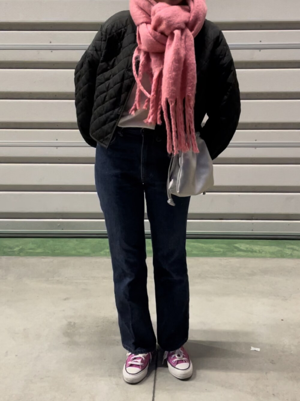 ブラック系のノーカラージャケット、シルバー系のショルダーバッグ、ピンク系のスニーカーを着用したレディースの冬コーディネートの2枚目の写真