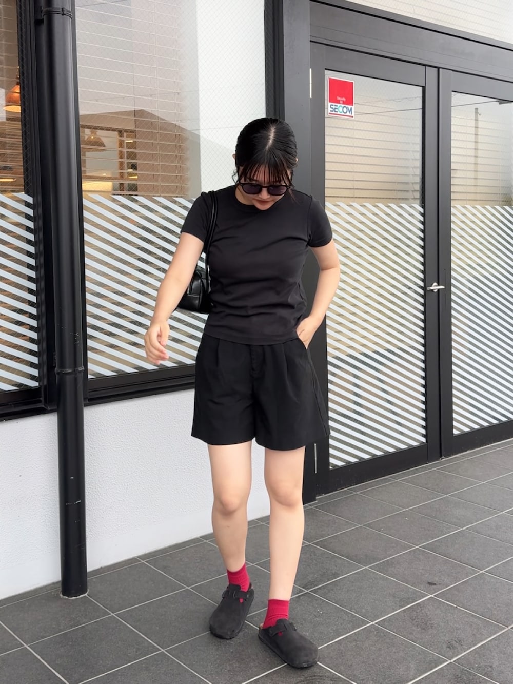 ブラック系のトートバッグ、ブラック系のサンダル、ブラック系のその他パンツを着用したレディースの夏コーディネートの2枚目の写真