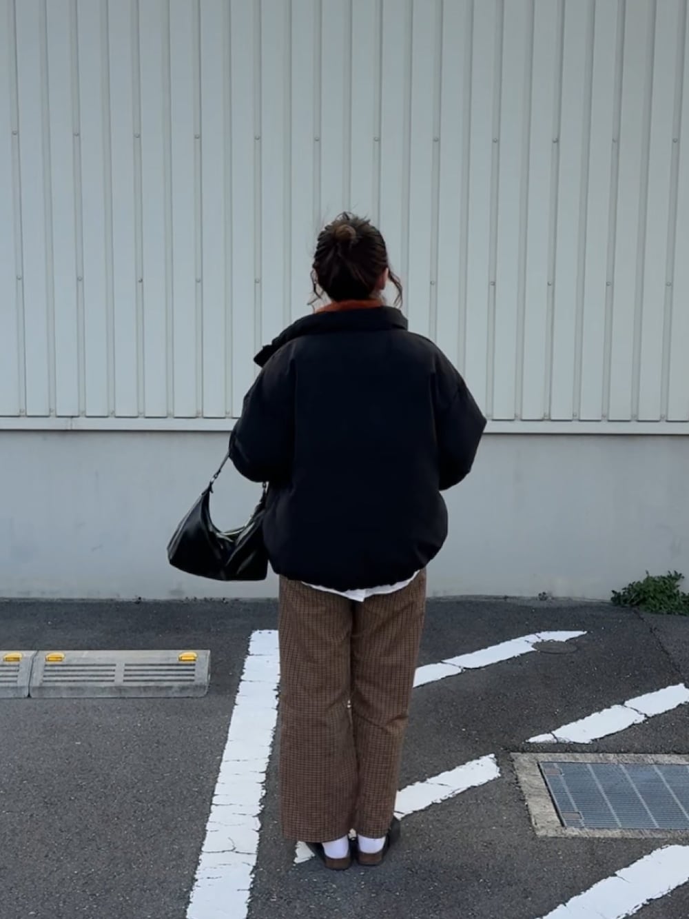 オレンジ系のニット/セーター、ブラック系のトートバッグ、ブラック系のサンダルを着用したレディースの冬コーディネートの2枚目の写真