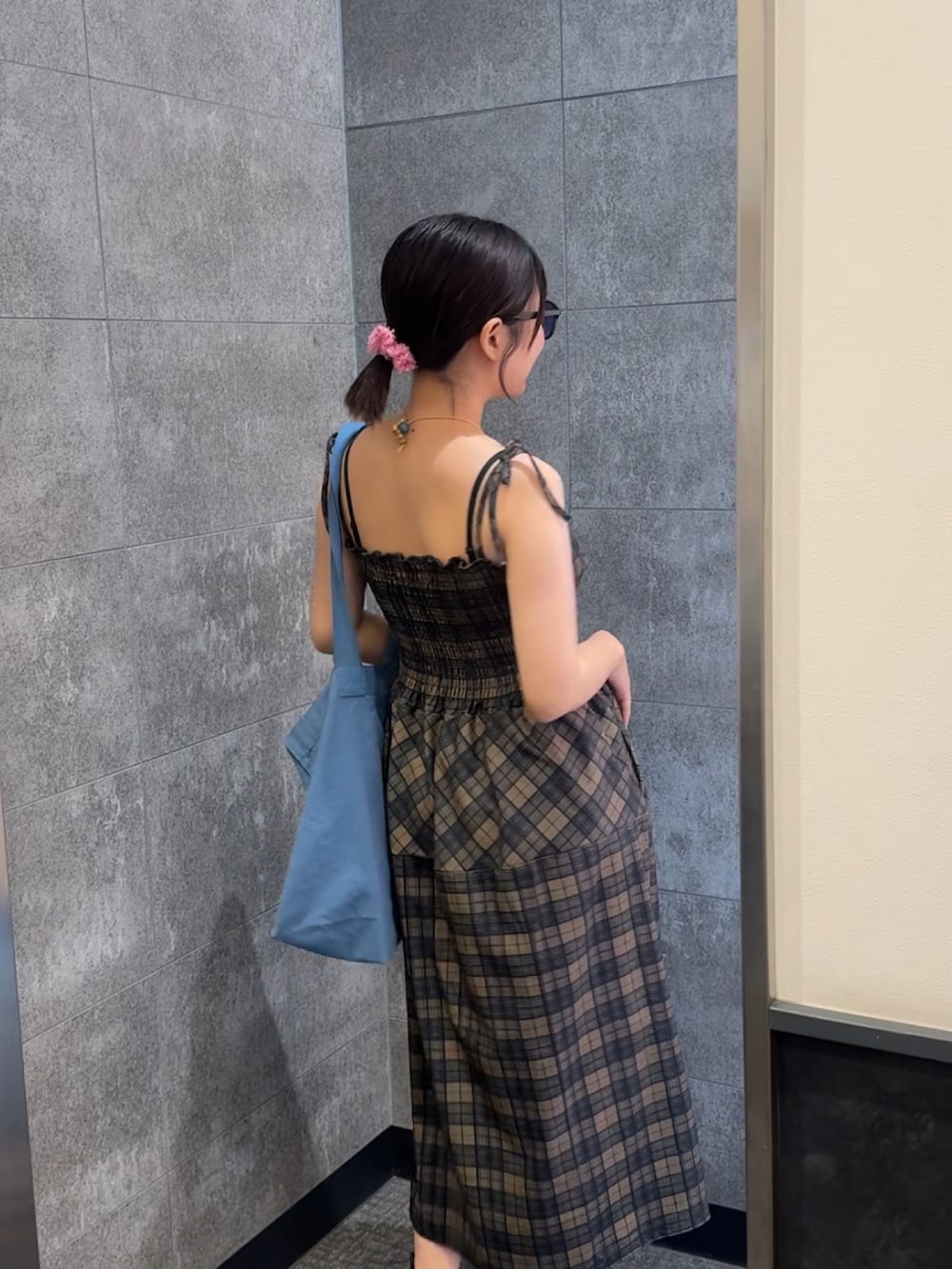 ブルー系のトートバッグ、ブラック系のサンダル、グリーン系のワンピースを着用したレディースの夏コーディネートの3枚目の写真