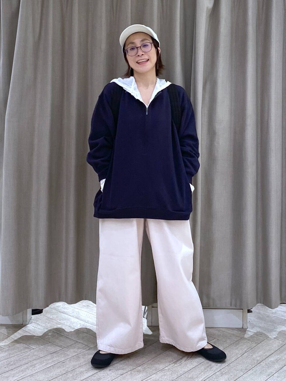 ブルー系のスウェット、ブラック系のショルダーバッグ、ピンク系のチノパンツを着用したレディースの冬コーディネートの2枚目の写真