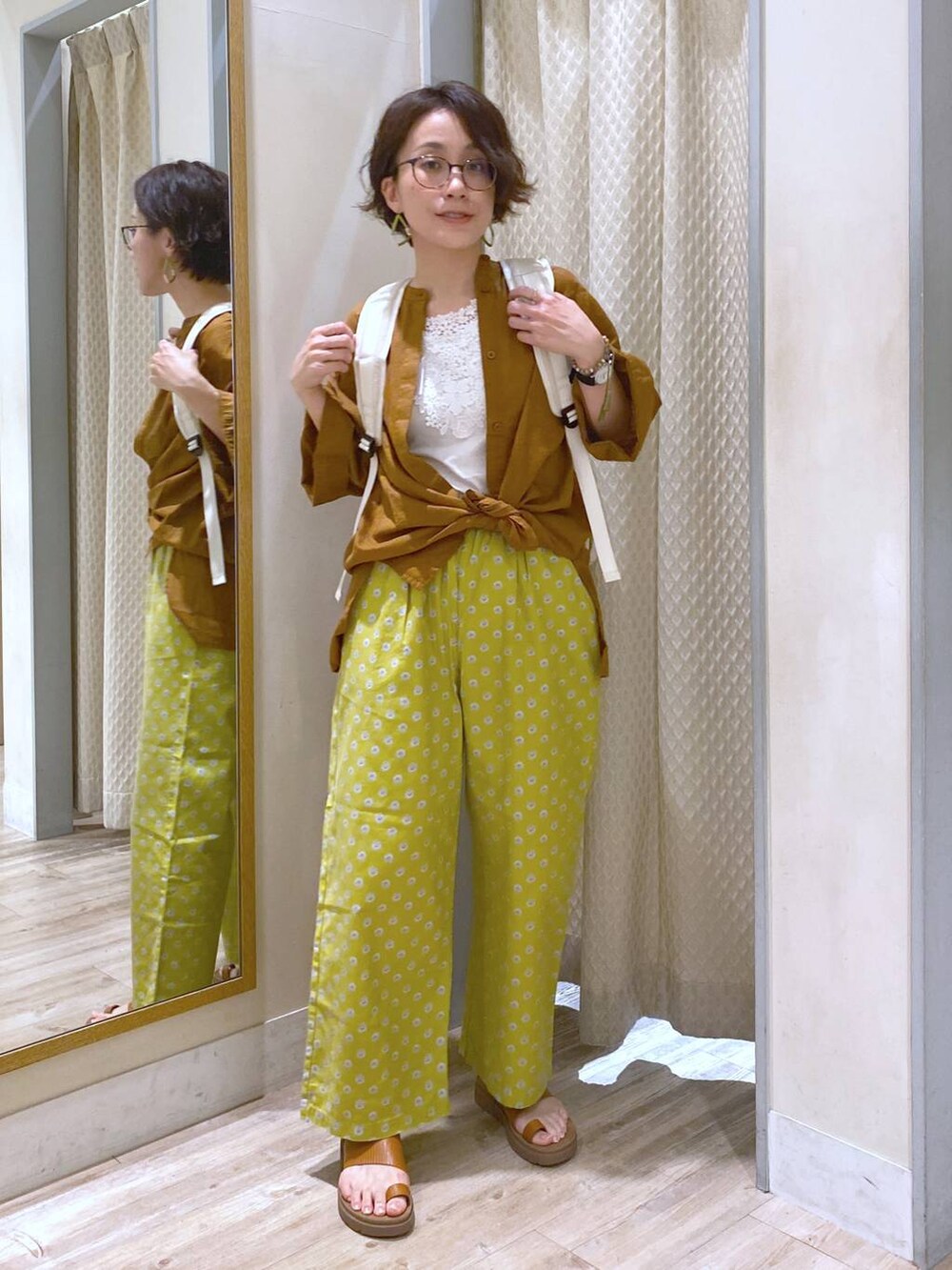 ブラウン系のサンダル、ホワイト系のバックパック/リュック、ホワイト系のタンクトップを着用したレディースの夏コーディネートの2枚目の写真