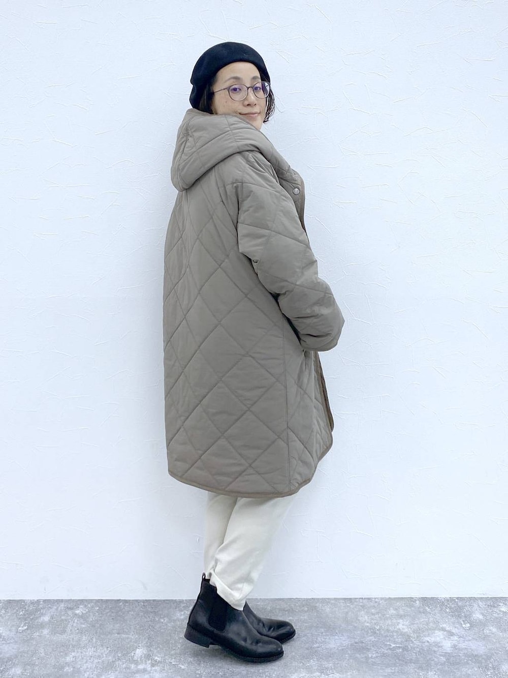 ブラック系のブーツ、ブラウン系のダウンジャケット/コート、ブラック系のショルダーバッグを着用したレディースの冬コーディネートの6枚目の写真