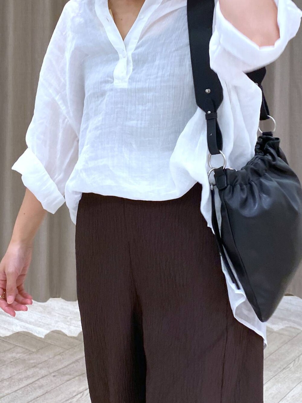 ホワイト系のシャツ/ブラウス、グレー系のパンプス、ブラウン系のその他パンツを着用したレディースの秋コーディネートの6枚目の写真