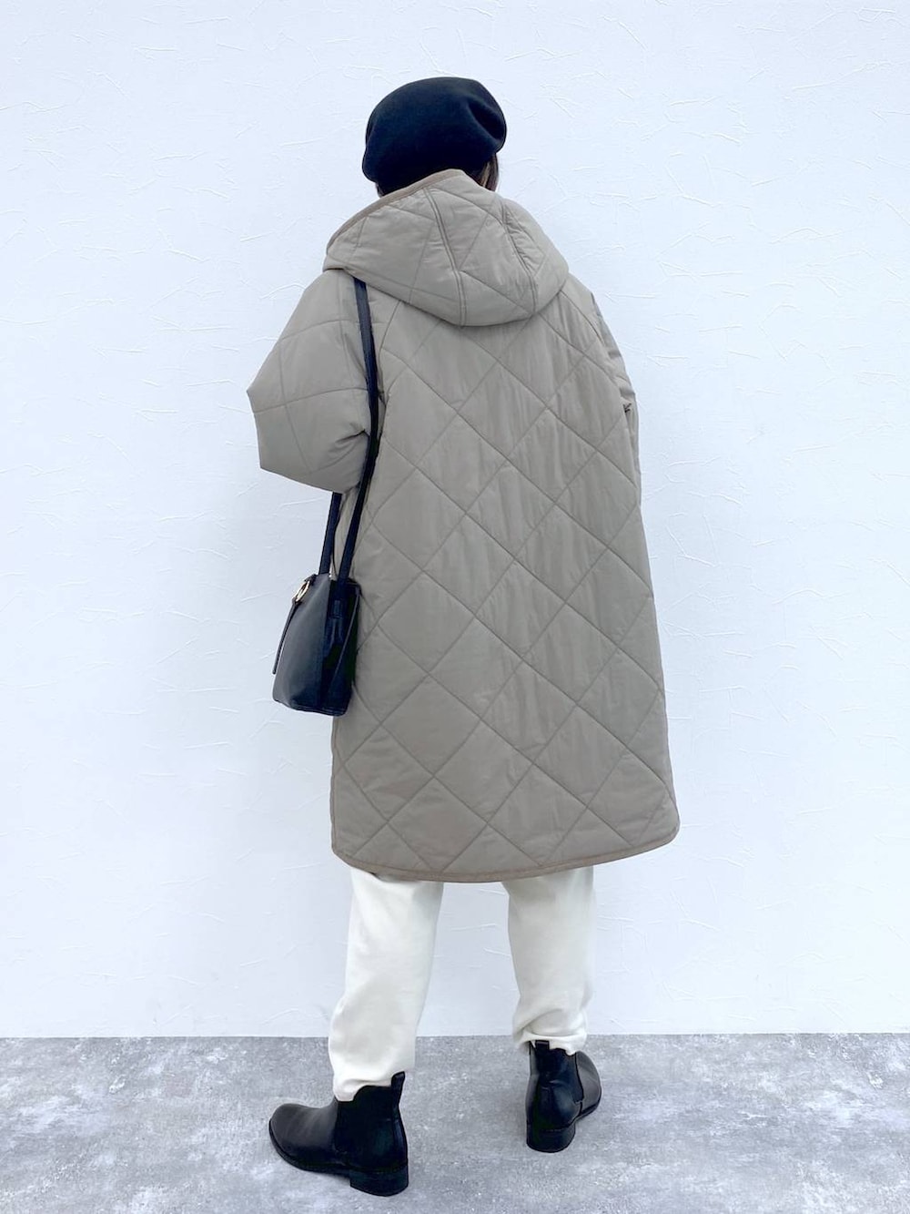 ブラック系のブーツ、ブラウン系のダウンジャケット/コート、ブラック系のショルダーバッグを着用したレディースの冬コーディネートの4枚目の写真