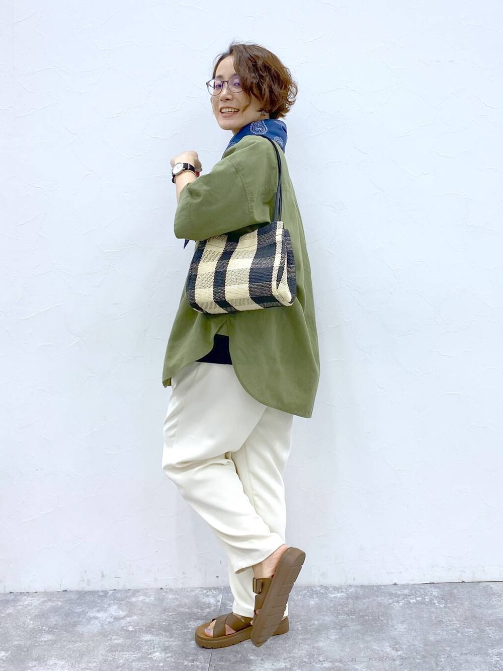 ブラウン系のサンダル、グリーン系のシャツ/ブラウス、ブラック系のトートバッグを着用したレディースの夏コーディネートの3枚目の写真