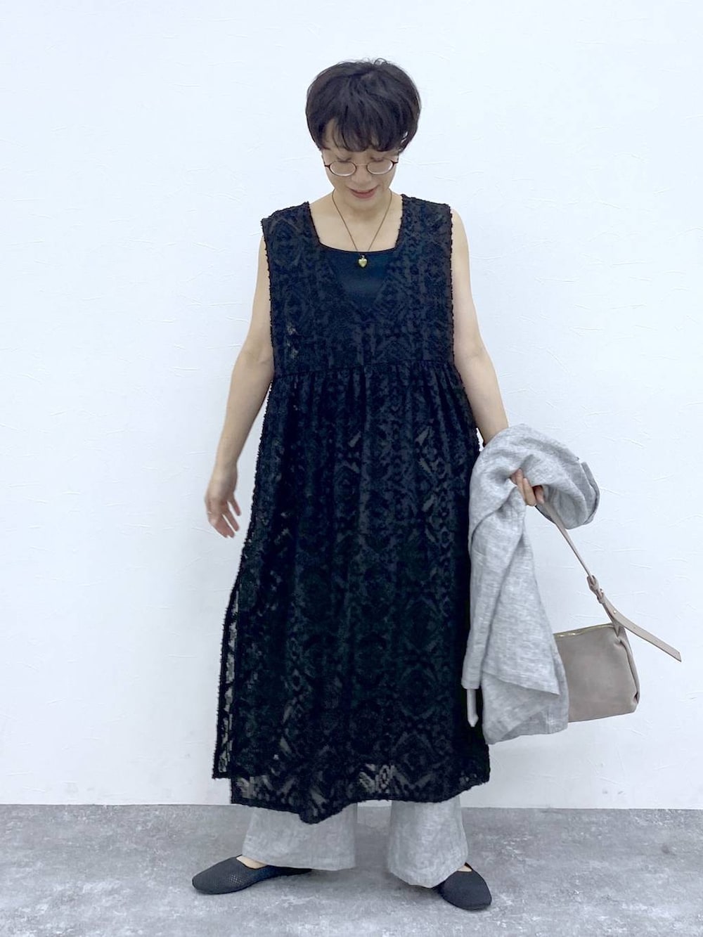 ブラック系のTシャツ/カットソー、ブラック系のベスト、グレー系のショルダーバッグを着用したレディースの春コーディネートの9枚目の写真