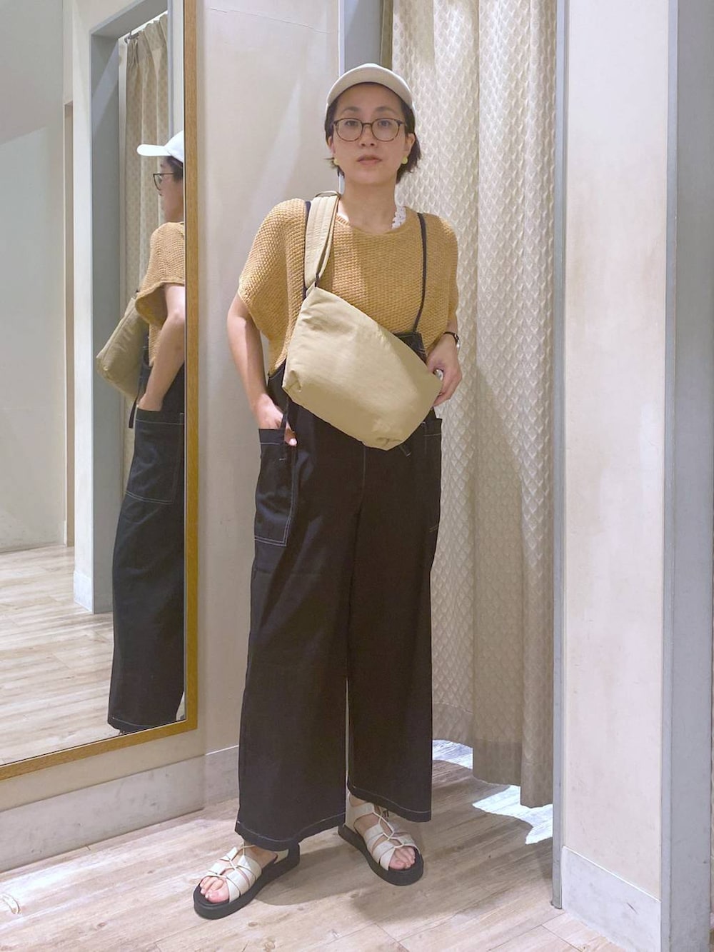 ブラック系のサロペット/オーバーオール、ホワイト系のタンクトップ、ホワイト系のサンダルを着用したレディースの夏コーディネートの2枚目の写真