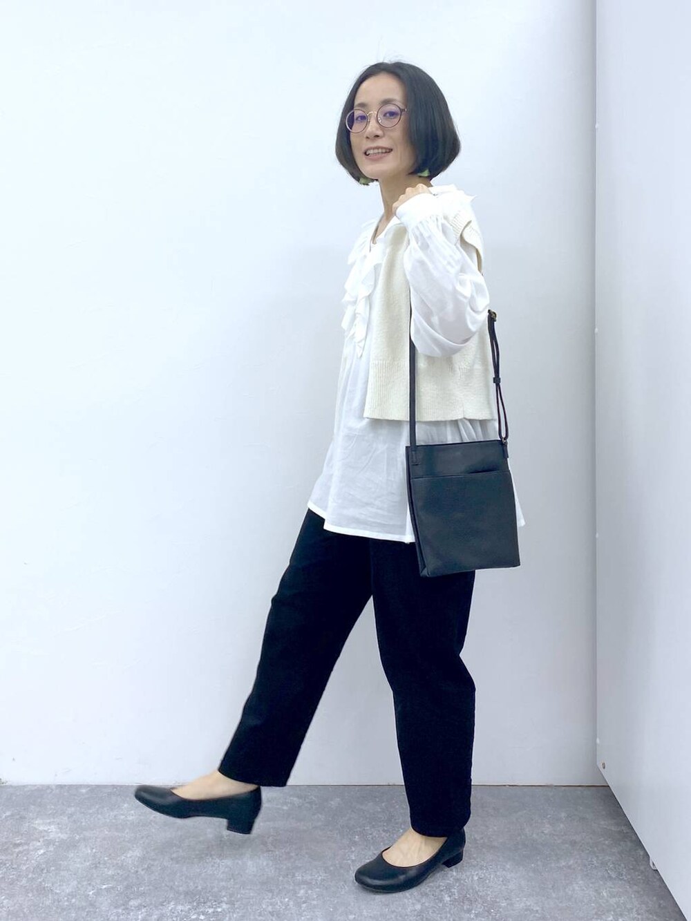 ホワイト系のシャツ/ブラウス、グレー系のタンクトップ、ブラック系のパンプスを着用したレディースの冬コーディネートの3枚目の写真